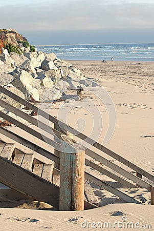 Wood stairs and rocks on beach in California Stock Photo