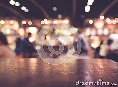 Wood table top on blur cafe restaurant in dark night with ligh Stock Photo