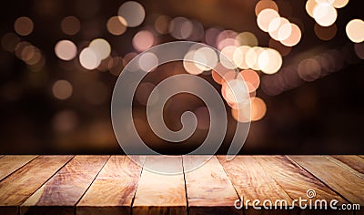 Wood table top with blur light bokeh in dark night cafe Stock Photo