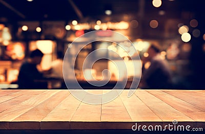 Wood table top with blur light bokeh in night cafe background Stock Photo