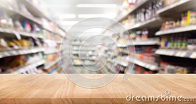 Wood table top on blur of supermarket product shelf background. Stock Photo