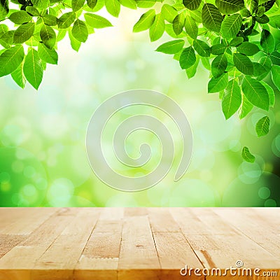 Wood table top with green leaf & blur bokeh background Stock Photo