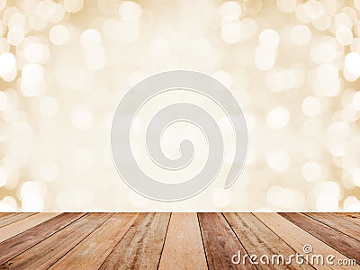 Wood table top over abstract golden background with white bokeh for Christmas and new year holidays. Montage style to display the Stock Photo