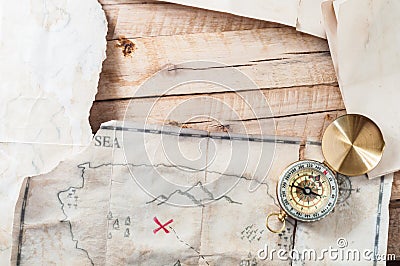 Wood table with vintage aged paper and ancient Treasure map with Compass. With space for your design Stock Photo