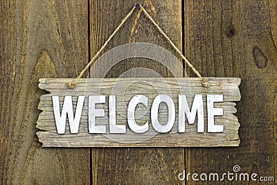 Wood welcome sign hanging on rustic wooden background Stock Photo