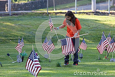 Volunteers placing an American Flag on the grave of a Military Veteran for Memorial Day Editorial Stock Photo