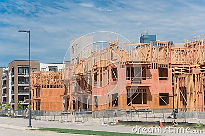 Wooden apartment complex under construction near completed condos and commercial building Stock Photo