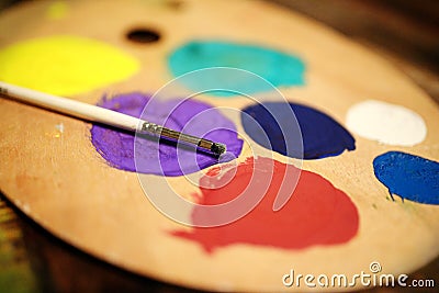 Wooden art palette with paint and brush on vintage background Stock Photo