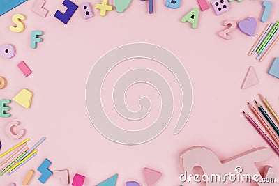 Wooden baby toys on a pastel pink background. Horse, numbers, blocks, puzzle shapes, pyramid, rainbow. Stock Photo