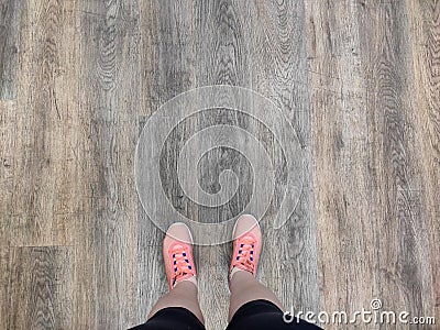 Wooden background and foots. Pink shoes on old wooden texture. Stock Photo
