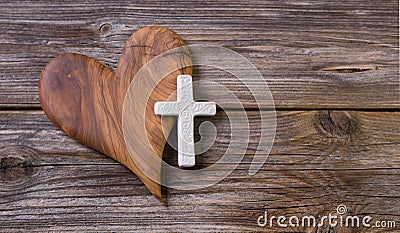 Wooden background with olive heart and white cross for an obituary notice. Stock Photo