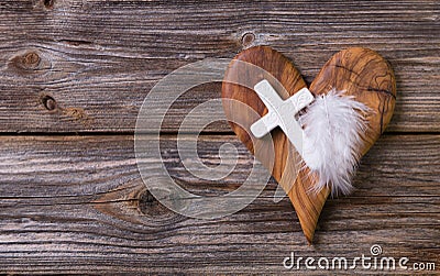 Wooden background with olive heart and white cross for an obituary notice. Stock Photo