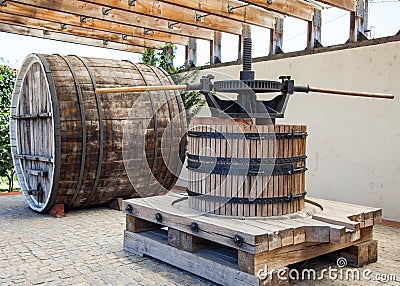 Old wooden barrel and press for making wine. Stock Photo