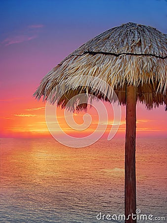 Wooden beach umbrella in golden orange sunset Stock Photo