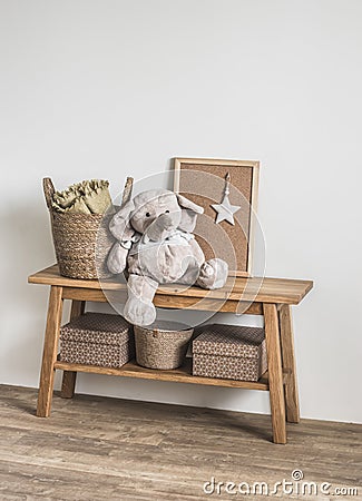 Wooden bench, basket with blankets, stuffed elephant toy in the interior of the children`s room Stock Photo