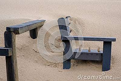 Wooden bench covered in sand on the beach at Boggams Bay on the Garden Route, South Africa. Stock Photo