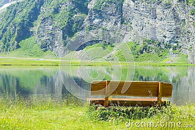 Wooden bench in front of a mountain lake Stock Photo