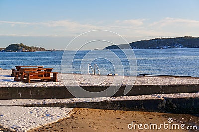 Wooden bench on the shore of the fjord Stock Photo