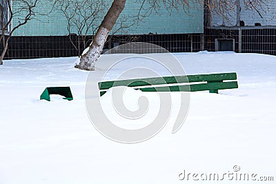 Wooden bench in winter under the snow, inaction of snow blowers in the snowfall Stock Photo