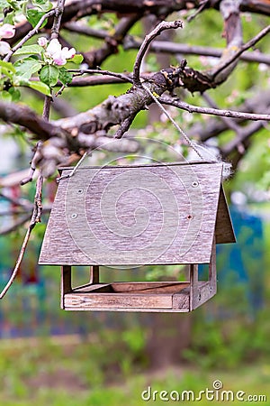 Wooden birdhouse bird feeder side view hanging on a branch Stock Photo