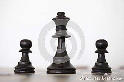 Wooden black queen and two pawns chess pieces Stock Photo