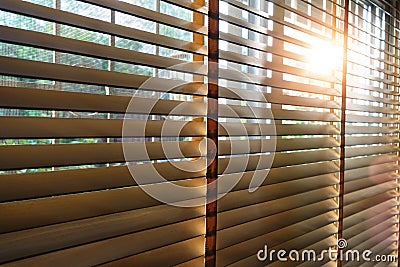 Wooden blinds in a home catching the sunlight with burst light Stock Photo