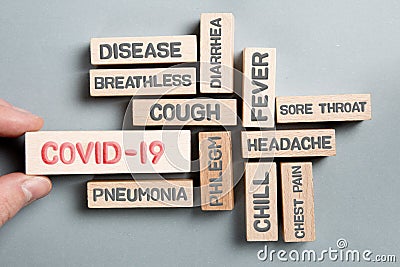 Wooden Blocks with COVID-19 Symptoms Stock Photo