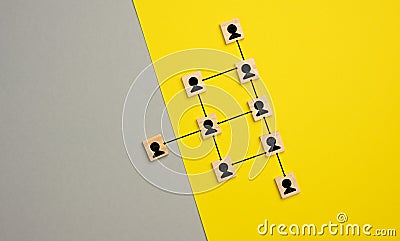 Wooden blocks with figures on a gray yellow background, hierarchical organizational structure of managemen Stock Photo