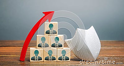 Wooden blocks with the image of a team of workers and a shield with up arrow. Working staff insurance concept. Employee protection Stock Photo