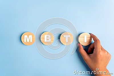 Wooden blocks with the letters MBTI on blue background. Personality typology. Psychology test for human types.MBTI - Myers-Briggs Stock Photo