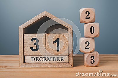 Wooden blocks lined up with 2023 numbers and wooden house on December 31st, last day of the year goal concept Stock Photo