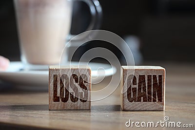 Wooden blocks on wooden table with Loss and Gain words. Money finance business concept Stock Photo