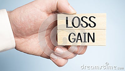 Wooden blocks on wooden table with Loss and Gain words. Money finance assets credit debt profitability loss and gain business Stock Photo