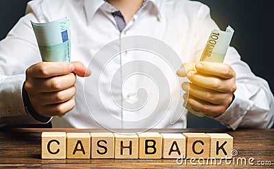 Wooden blocks with the word Cashback and money in the hands of a businessman. Bonus program to attract customers and increase Stock Photo