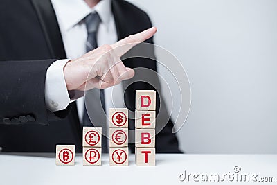 Wooden blocks with word debt currency icons: us dollar, euro, ruble, yuan, pound sterling, bitcoin, businessman pointing Stock Photo