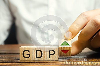 Wooden blocks with the word GDP and up and down arrows. An unstable economy in the country. Financial measure of the market value Stock Photo