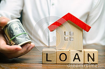 Wooden blocks with the word Loan, house and money in the hands of a businessman. The concept of buying an apartment or house in Stock Photo