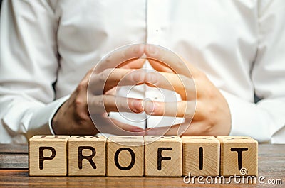 Wooden blocks with the word Profit and businessman. Analysis of profits in the company. Strategy to improve business performance. Stock Photo