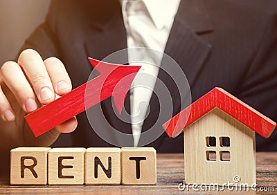 Wooden blocks with the word Rent, house and up arrow. The concept of the high cost of rent for an apartment or home. Interest Stock Photo