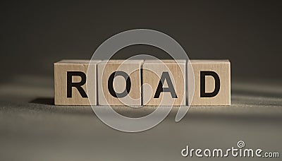 A wooden blocks with the word ROAD written on it on a gray background Stock Photo