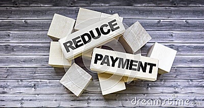 Wooden blocks with the words Reduce payment. Stock Photo
