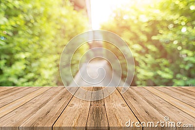 Wooden board empty table blur trees in forest background - can be used mock up for display or montage your products. Stock Photo