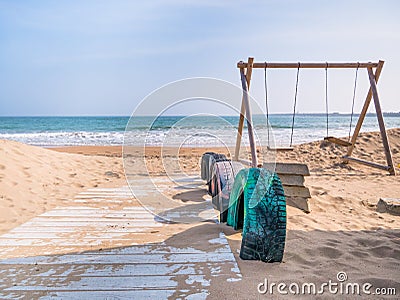 Wooden board path over the sand and swings at Mangalia beach, in Romania Stock Photo