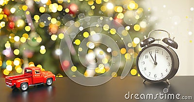 On the wooden board is a red toy car, a New Year's clock, blurred lights Stock Photo