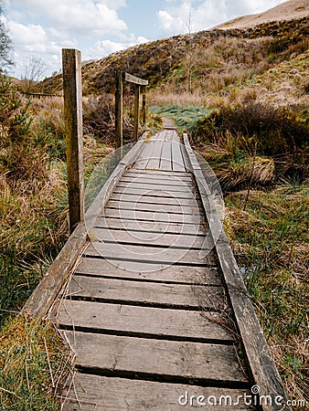 Wooden boardwalk over muddy swampy boggy ground in the UK country side at Rivington Pike . Stock Photo