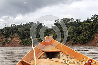 Wooden boat front and green jungle landscape, sailing in the muddy water of the Beni river, Amazonian rainforest, Bolivia Stock Photo