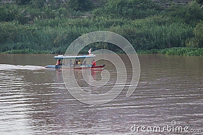 A wooden boat sailing in the Chao Phraya River, Nakhon Sawan Province, Thailand Editorial Stock Photo