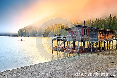 Wooden boathouse with boats on the alpine lake, Dolomites, Italy Stock Photo