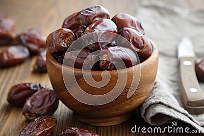 Wooden bowl of dates fruits and knife. Stock Photo