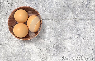 Wooden bowl ful of eggs. Placed on concrete table. Stock Photo